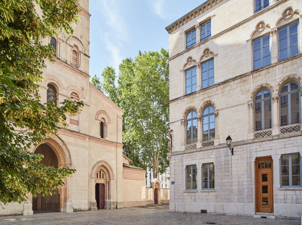 Place de l&#039;Abbaye com, à esquerda, a fachada da Basilique - Abbaye Saint-Martin d&#039;Ainay e, à direita, a fachada do Hôtel de l&#039;Abbaye e do Café Basilic