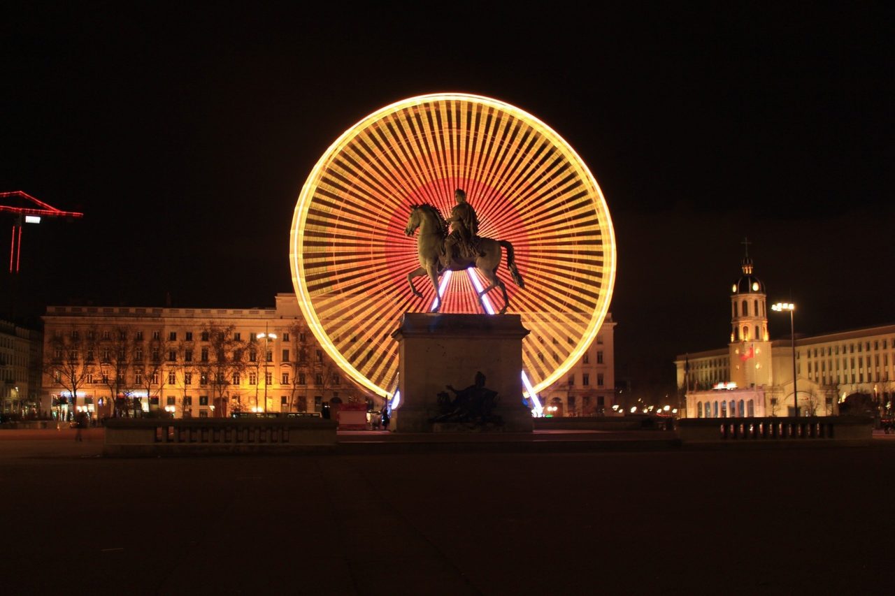 Statua equestre di Luigi XIV e ruota panoramica di Place Bellecour vista di notte