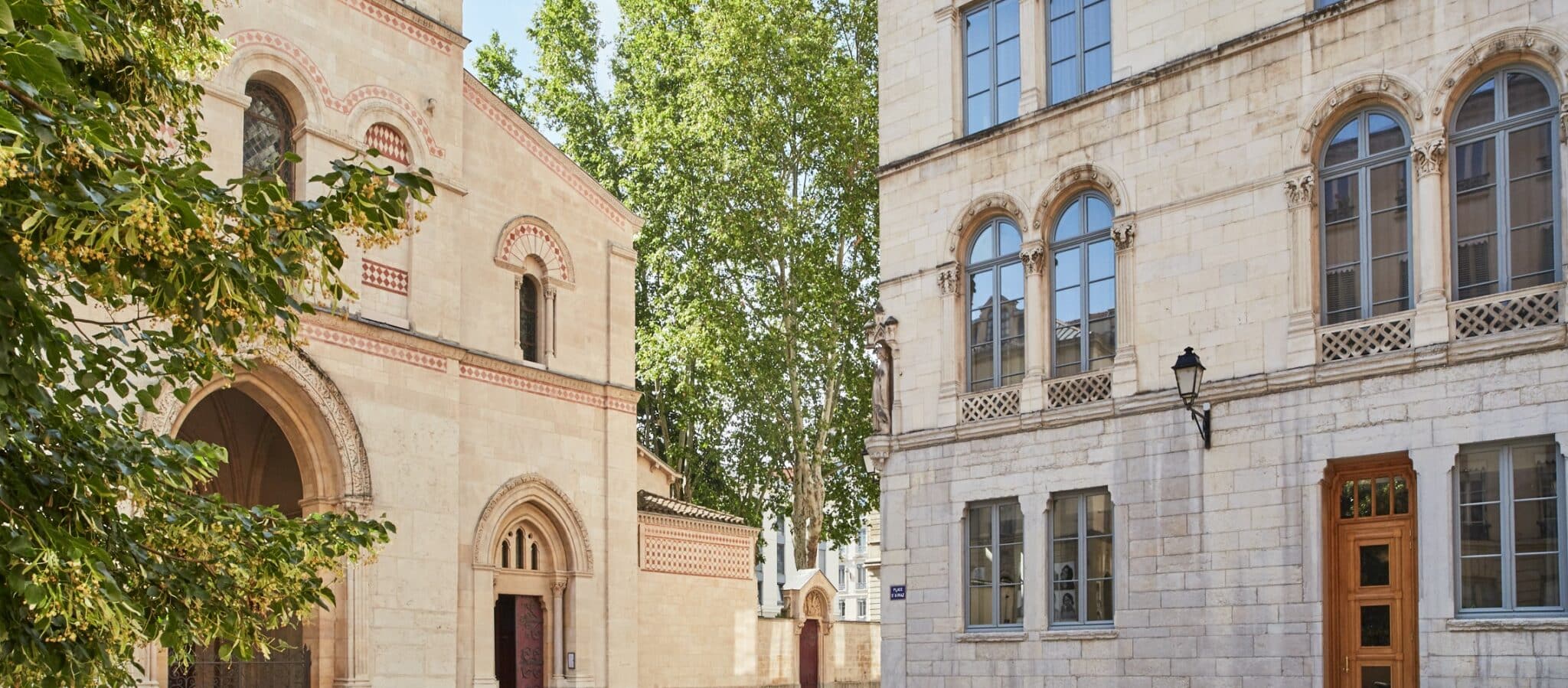 Place de l'Abbaye avec à gauche, la façade de la Basilique - Abbaye Saint-Martin d'Ainay et, à droite, la façade de l'Hôtel de l'Abbaye et du Café Basilic